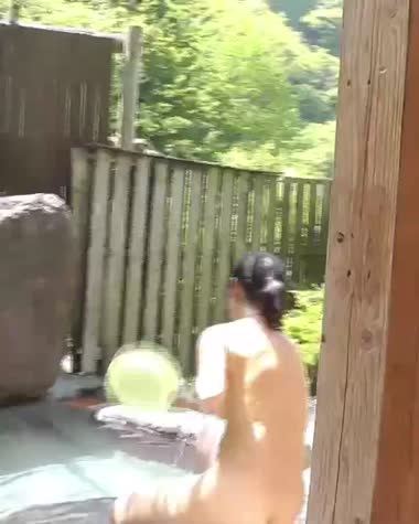 露天風呂でかけ湯する妻
